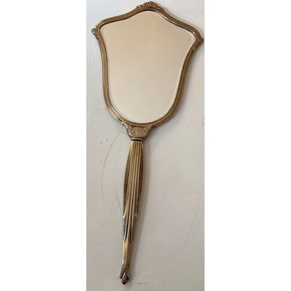 Vintage or antique gold-tone handheld vanity mirror.